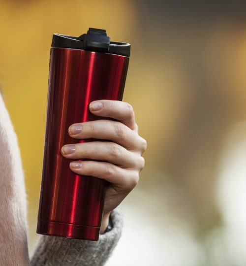 Thermo,Cup,In,Female,Hands,Against,The,Background,Of,Autumn